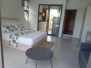 1 dormitorio con 1 cama, 1 mesa y 1 silla en The Starlight, en Grande Rivière Sud Est