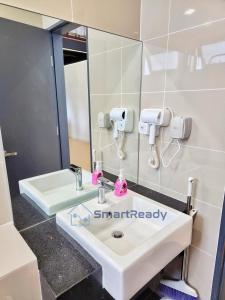 a bathroom with a sink and a mirror at Sunway GRID by SR Home in Kampong Pendas