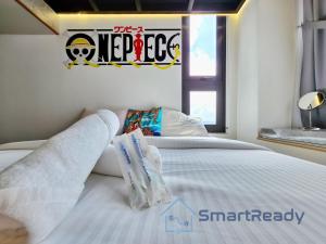 a bedroom with a bed with white sheets and a window at Sunway GRID by SR Home in Kampong Pendas