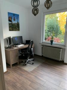 un bureau avec un bureau, un ordinateur et une fenêtre dans l'établissement Entspannung am Niederrhein - großes helles Haus mit Kamin, à Emmerich