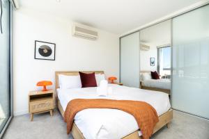 1 dormitorio con 1 cama blanca grande y paredes de cristal en 2BR Penthouse with Breathtaking View! - Hosted by CanStay, en Canberra