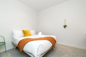 Dormitorio blanco con cama con almohadas amarillas en 2BR Penthouse with Breathtaking View! - Hosted by CanStay, en Canberra