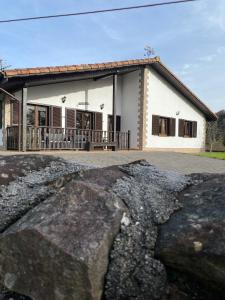 un bâtiment avec un grand rocher devant lui dans l'établissement Casa Rural Laurenea, à Alzate