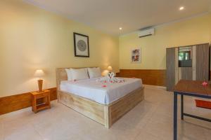 een slaapkamer met een groot bed in een kamer bij Grand Ball Beach Garden in Nusa Penida