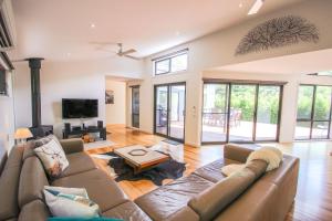 a living room with a couch and a tv at The Base One in Harrietville