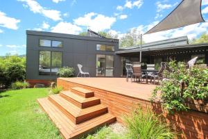 a house with a wooden deck in the yard at The Base One in Harrietville