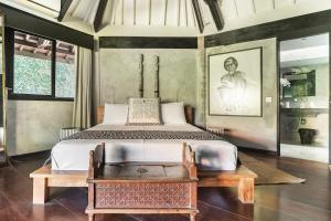 a bedroom with a king sized bed and a table at Villa Fi in Seminyak