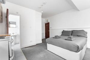 a white bedroom with a bed and a sink at Finchley Road Studio 13 in London