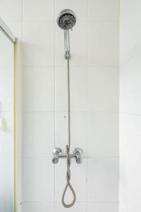 a shower with a shower head in a bathroom at Finchley Road Studio 13 in London