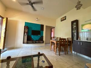 a living room with a table and a tv at sacred river homestay in Alleppey