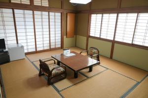 a room with a table and chairs and windows at HOTEL LT Kitchen 湯河原 in Yugawara