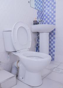 a bathroom with a white toilet and a sink at Tiny Haven executive one bedroom with Private Balcony in Nanyuki