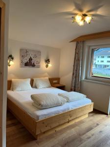 a bedroom with a wooden bed with a window at Jedelerhof in Neustift im Stubaital