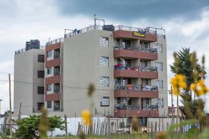 a tall apartment building with people on the balconies at Tiny Haven executive one bedroom with Private Balcony in Nanyuki