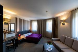 a hotel room with a bed and a couch at Art Hotel in Slavonski Brod