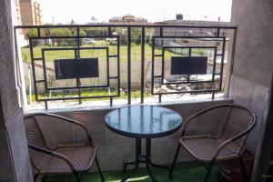 a table and chairs on a balcony with a view at Tiny Haven executive one bedroom with Private Balcony in Nanyuki