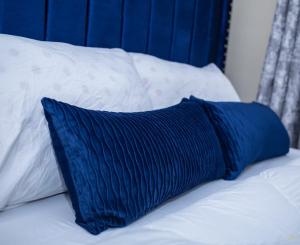 a blue pillow sitting on top of a bed at Tiny Haven executive one bedroom with Private Balcony in Nanyuki