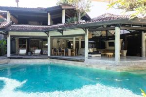 a house with a swimming pool in front of a house at Villa Fi in Seminyak