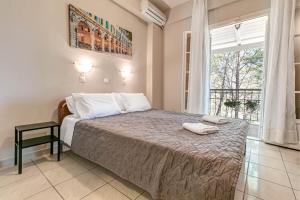 a bedroom with a bed and a large window at Alexandros Apartments in Ipsos