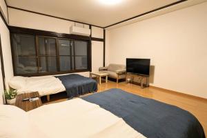 Een bed of bedden in een kamer bij 万博会場まで直通2駅10分USJ海遊館近い 朝潮橋駅徒歩4分無料駐車場有り最大12名宿泊可能 Wifi ベビー用品充実