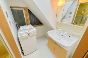een badkamer met een wastafel en een spiegel bij 万博会場まで直通2駅10分USJ海遊館近い 朝潮橋駅徒歩4分無料駐車場有り最大12名宿泊可能 Wifi ベビー用品充実 in Osaka +36 foto's