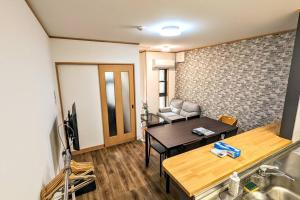 een woonkamer met een tafel en een bank bij 万博会場まで直通2駅10分USJ海遊館近い 朝潮橋駅徒歩4分無料駐車場有り最大12名宿泊可能 Wifi ベビー用品充実 in Osaka