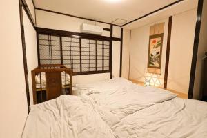 Een bed of bedden in een kamer bij 万博会場まで直通2駅10分USJ海遊館近い 朝潮橋駅徒歩4分無料駐車場有り最大12名宿泊可能 Wifi ベビー用品充実
