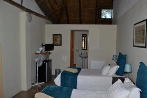 a bedroom with a bed with blue and white pillows at Thorn Tree Bloemfontein in Bloemfontein