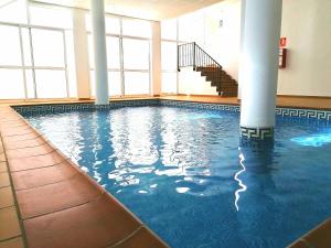 a swimming pool in a large building with columns at CASA DIEGO PUERTO BLANQUILLO in Frigiliana