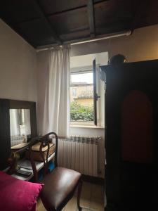 een woonkamer met een stoel en een raam bij Casa Otto in Fara in Sabina
