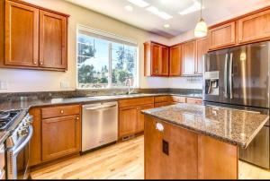 a kitchen with wooden cabinets and stainless steel appliances at EV4 DREAMZ VILLA Spacious and cozy in Everett