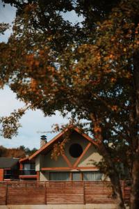 una casa detrás de una valla y un árbol en Abant Cozy Homes, en Bolu