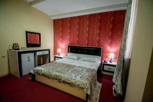 1 dormitorio con 1 cama con pared roja en BATONI, en Tiflis