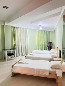 1 dormitorio con 4 camas y escritorio. en BATONI, en Tiflis