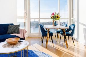 ein Wohnzimmer mit einem Tisch und blauen Stühlen in der Unterkunft Riverview 2 Bedroom and 2 Bath Apartment in London