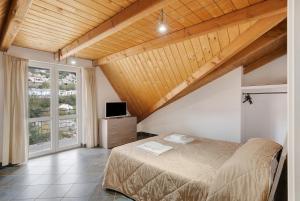 1 dormitorio con 1 cama, TV y ventana en Parco San Lorenzo 4, en Fisciano