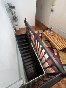 a staircase with a wooden bench and a wooden table at SPOT ON 90898 Kasturi Alley Guest House & Cat Hotel in Melaka