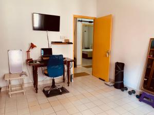 a room with a desk and a chair and a television at The Sheltuh : Closer to everything Colombo in Manning Town
