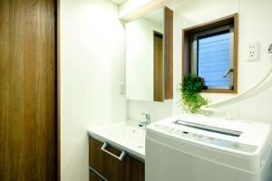 a bathroom with a sink and a washing machine at Home n Lounge in Tokyo