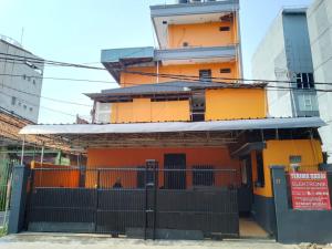 een oranje gebouw met een poort ervoor bij Penginapan 21 By SPAZIE in Jakarta