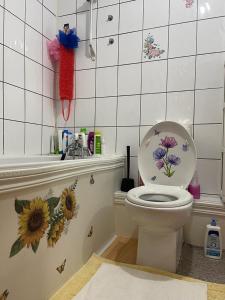 baño con aseo con flores en la pared en Luxury Triple Room en Londres