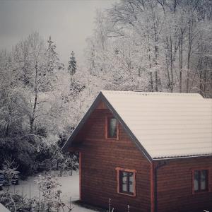 a house with snow on the roof of it at Ostoja nad potokiem Dwernik in Dwernik