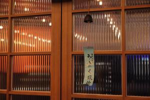 uma janela com um sinal num quarto em Aank Ryokan Yosuriguri Hotel em Cheonan