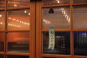 a window with a sign on it in a room at Annk Ryokan Yosuriguri Hotel in Cheonan