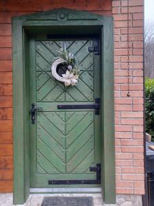 a green door with a wreath on top of it at Vintage riverside house Slapnica, in the Žumberak Nature Park, finnish sauna and jacuzzi in Krašić