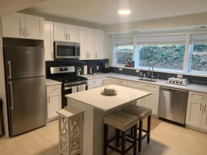 a kitchen with white cabinets and a refrigerator and a table at West Taylor Run Hotel in Alexandria