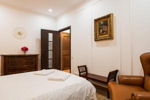 a bedroom with a bed and a chair and a mirror at Apollonia eState OLD TOWN BIG AND LUXURIOUS in Braşov