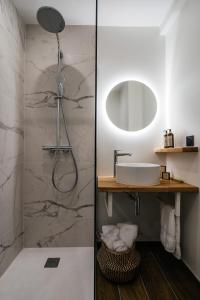 a bathroom with a shower with a sink and a mirror at Auberge du Lyonnais in Annecy