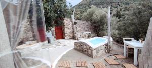 a patio with a pool and a table and a building at Kamihis Farm House Experience in Zaros