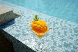 a pineapple cocktail in a wine glass next to a pool at Holiday Inn Express Phuket Patong Beach Central, an IHG Hotel in Patong Beach